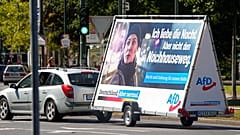 In this Wednesday, Aug. 25, 2021 file photo a car pulls an election poster for the right wing party 'Alternative for Germany' (AfD) at a street in Duesseldorf, Germany.