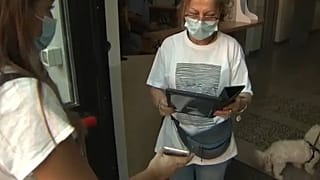 Una mujer enseña su pase verde en un colegio
