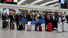 People queue at ticket machines at Heathrow airport in London, Wednesday, March 18, 2020. 