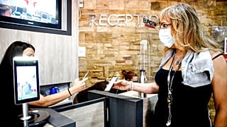 Eine Kundin zeigt ihren "Grünen Pass" am Eingang ihres Fitness-Studios vor, 6.8.2021