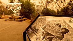Fire-resistant wrap covers a historic welcome sign as the KNP Complex Fire burns in Sequoia National Park, Calif., on Sept. 15, 2021. 