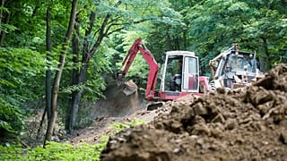 Munkagép dolgozik az újjáépítés alatt álló Márianosztra-Nagyirtáspuszta vasútvonalon Márianosztra közelében 2015. június 30-án.