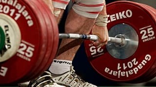An athelete lifts 185 kg in the clean and jerk of a men's 105 kg weightlifting competition. 