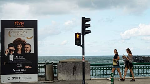 People walk past close to a poster promoting a film with Spanish actress Penelope Cruz