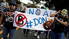 People take part in a protest against the use of Bitcoin as legal tender and legal reforms to extend president Nayib Bukele's term in San Salvador, September 15, 2021.