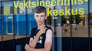 Joonas Leis , 12 years old boy, poses for a photo after getting a shot a coronavirus vaccine at a vaccination center inside a sports hall in Estonia.