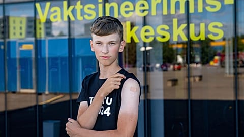 Joonas Leis , 12 years old boy, poses for a photo after getting a shot a coronavirus vaccine at a vaccination center inside a sports hall in Estonia.