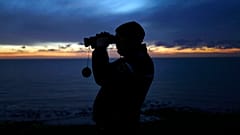 In this file photo dated Friday, Jan. 18, 2019, a French gendarme patrols the beach in Ambleteuse near Calais, northern France