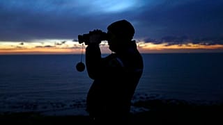 In this file photo dated Friday, Jan. 18, 2019, a French gendarme patrols the beach in Ambleteuse near Calais, northern France