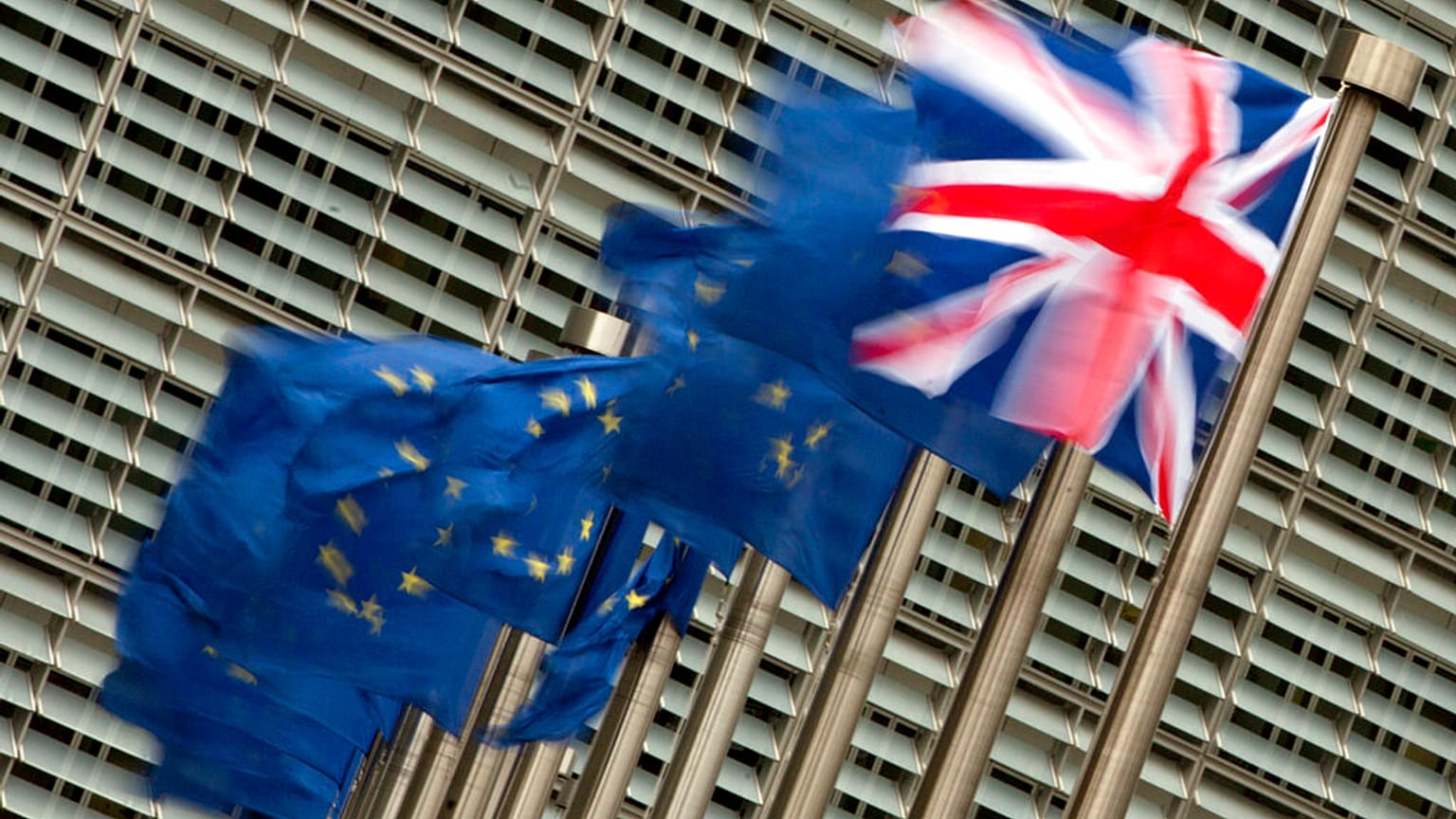 A Friday, Jan. 29, 2016 photo from files showing the British, right, and EU flags flapping in the wind outside of EU headquarters in Brussels.