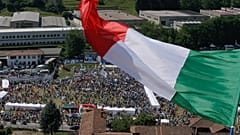 A man waves the Italian flag on a hill during a the traditional League party rally in Pontida in 2018.