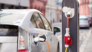 Toyota Prius connected to a charging station.