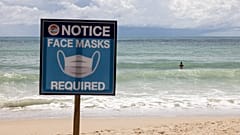 August 14, 2021 shows a sign reading "Face Masks Required" on Patong Beach in Phuket. 