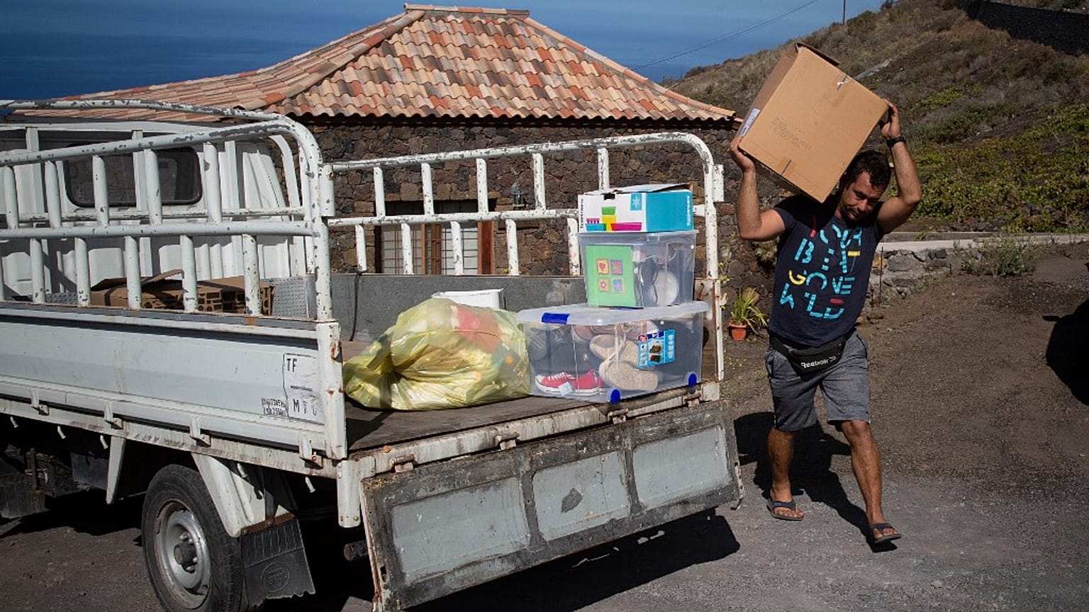 Edrey Concepcion loads his van with the neighbours' belongings as he helps during the evacuation of residents in Tacande due to the volcanic eruption in Cumbre Vieja.