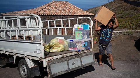 Edrey Concepcion loads his van with the neighbours' belongings as he helps during the evacuation of residents in Tacande due to the volcanic eruption in Cumbre Vieja.