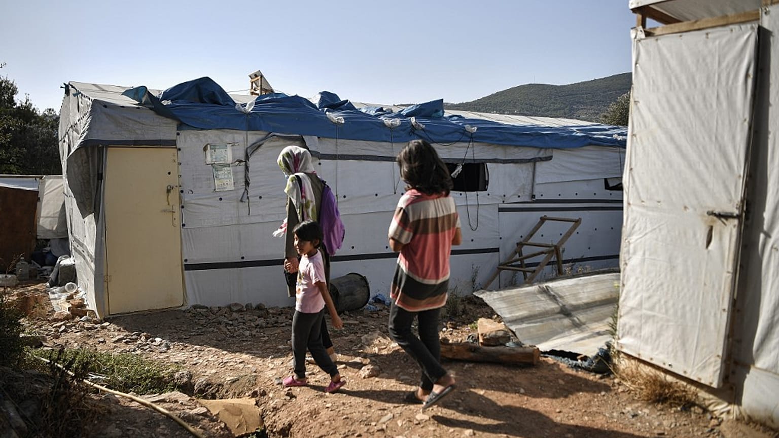 One of the very few remaining families walk in the 'jungle' part of the Samos old Reception and Indentification center in Vathy, on September 19, 2021.