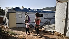 One of the very few remaining families walk in the 'jungle' part of the Samos old Reception and Indentification center in Vathy, on September 19, 2021.