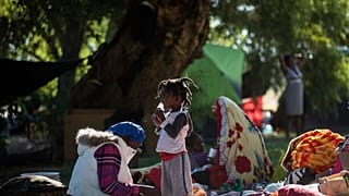 A girl drinks juice at a migrant camp in Ciudad Acuña, Mexico, Thursday, Sept. 23, 2021.