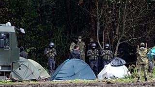 Polish security forces surround migrants stuck along with border with Belarus in Usnarz Gorny.