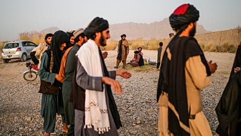 Taliban members enjoy a traditional dance on the banks of a river in Kandahar. 