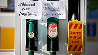 Hand written signs are stuck to a petrol pump with no fuel available at a Shell filling station in Manchester