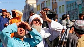 Menschen in Herat in Afghanistan blicken auf die an einem Kran hängenden Gehängten