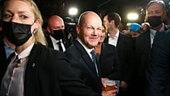 Olaf Scholz, center, Finance Minister and SPD candidate for Chancellor, drinks a beer as he leaves the election party at Willy Brandt House in Berlin