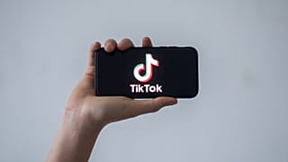 هاتف ذكي يحمل شعار شبكة التواصل الاجتماعي الصينية تيك توك.