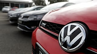 Display cars are parked at a Volkswagen dealership.