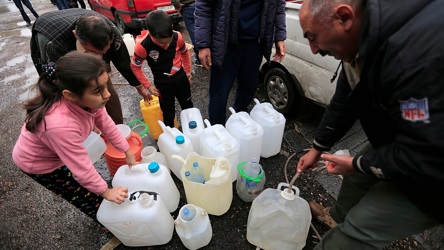 أشخاص يملأون أوعية بلاستيكية بمياه من صنبور ماء في دمشق، سوريا ، الاثنين ، 16 يناير / كانون الثاني 2017.