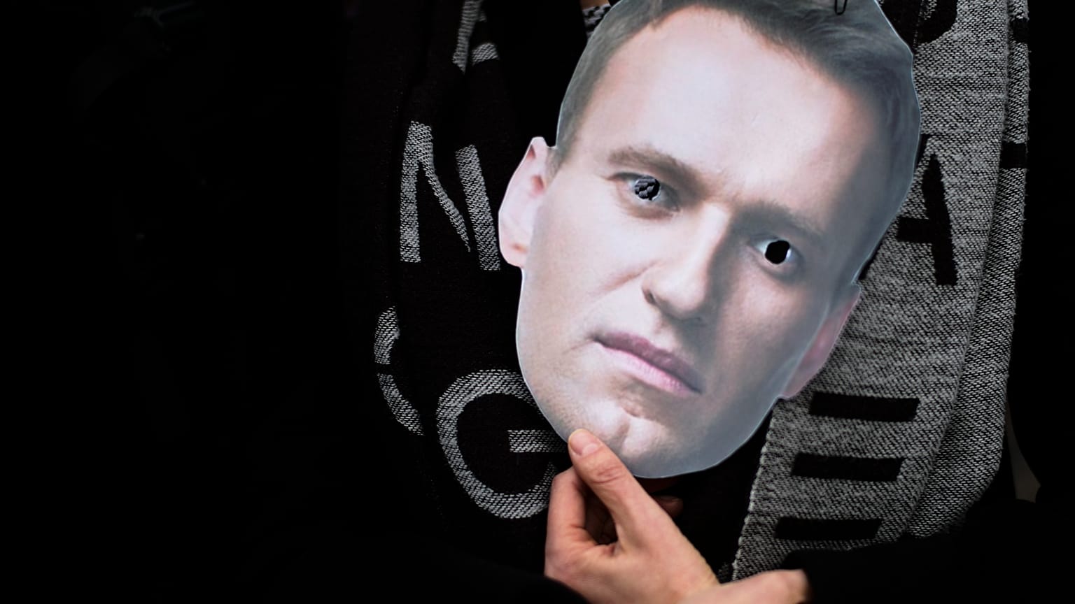 A mask of Russian opposition leader Alexei Navalny is held at a rally in Berlin.