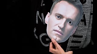 A mask of Russian opposition leader Alexei Navalny is held at a rally in Berlin.