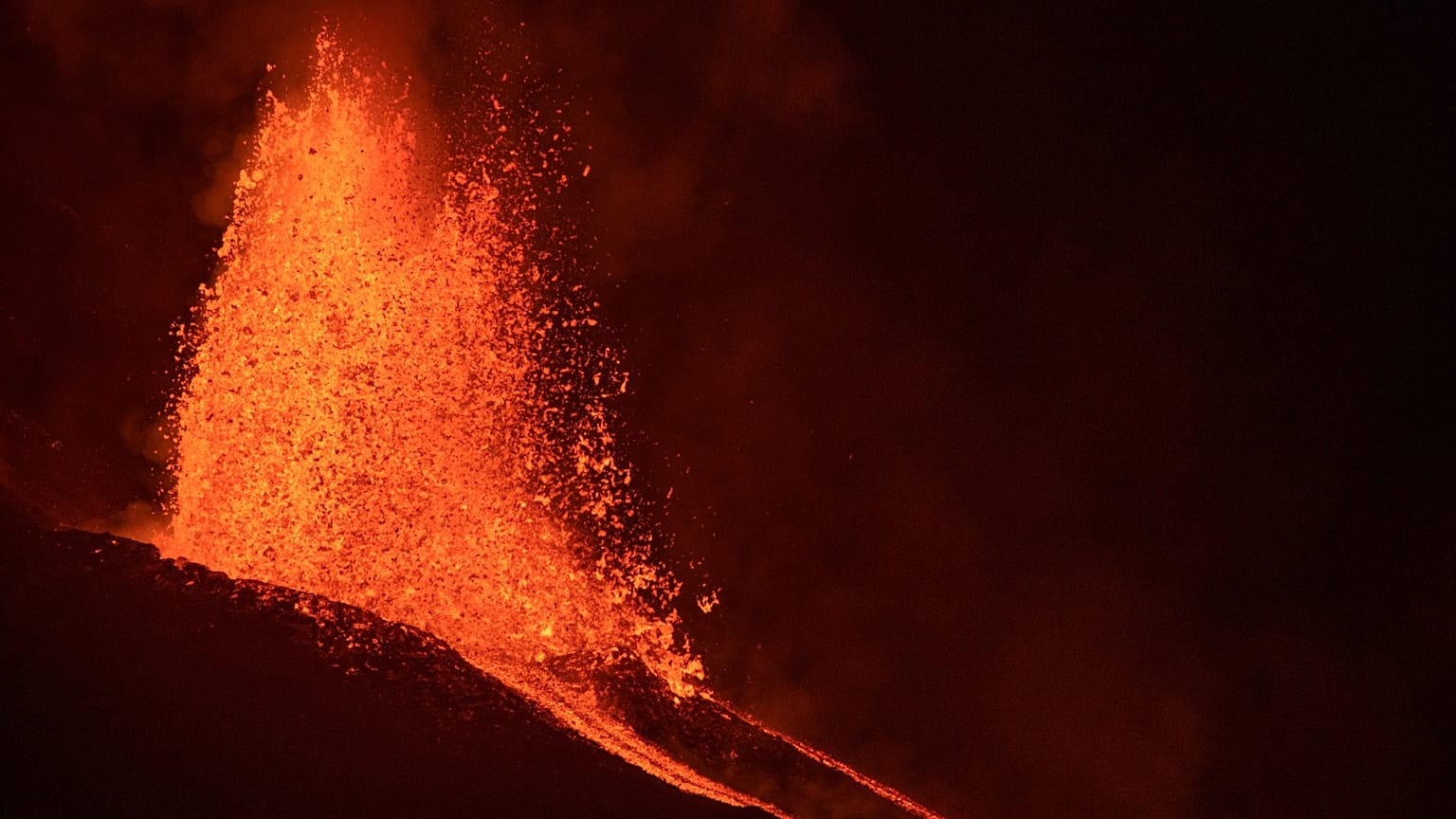 La lava fluye desde un volcán en la isla canaria de La Palma, España, en las primeras horas del martes 28 de septiembre de 2021.
