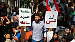 متظاهر يحمل لافتات خارج مبنى المحكمة خلال مظاهرة تضامن مع القاضي طارق بيطار الذي يحقق في انفجار ميناء بيروت، في بيروت، لبنان، الأربعاء 29 سبتمبر 2021