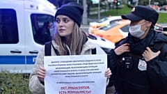A police officer detains a journalist holding a banner that reads: "There are no foreign agents, there are journalists," in Moscow, Russia, Sept. 8, 2021.