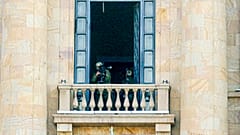 A security agent points a sniper rifle from a window of the Armenia parliament building.