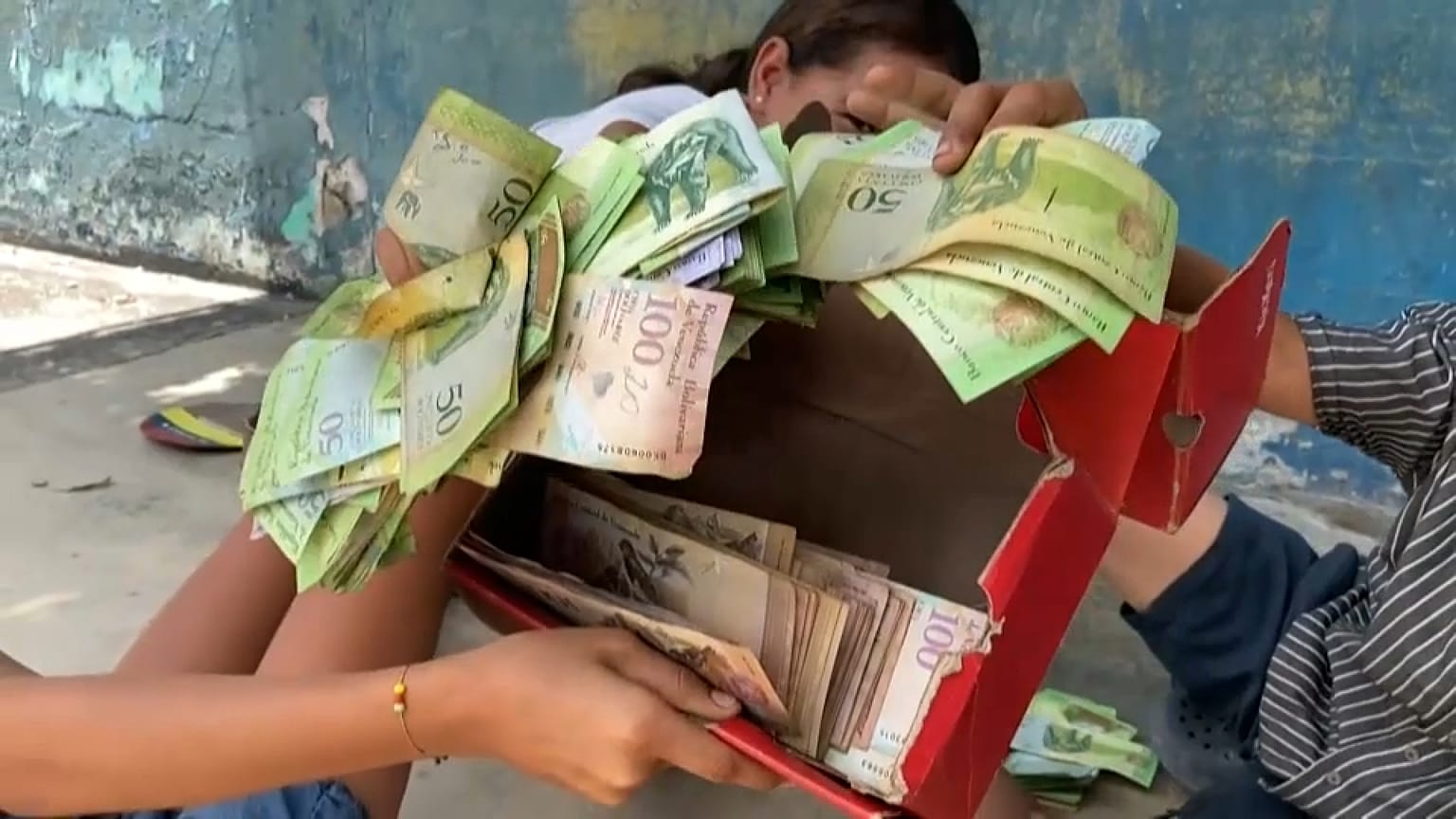 Niños juegan en la calle con bolívares