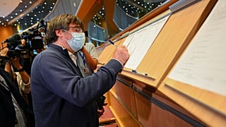 Catalan separatist leader and MEP Carles Puigdemont signs the attendance register prior to attending a committee meeting at the European Parliament in Brussels