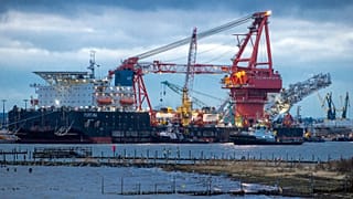 Tugboats get into position on the Russian pipe-laying vessel "Fortuna" in the port of Wismar, Germany, January 2021.