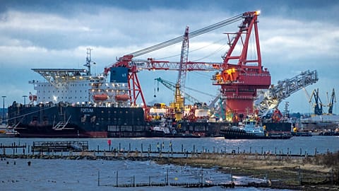Tugboats get into position on the Russian pipe-laying vessel "Fortuna" in the port of Wismar, Germany, January 2021.
