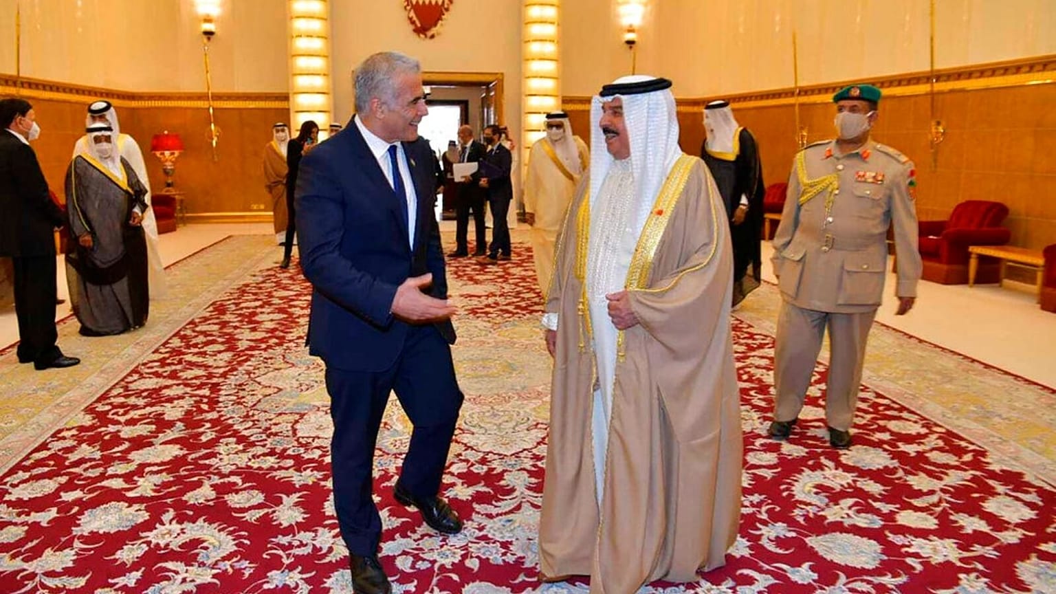 Israel's Foreign Minister Yair Lapid, walks with Bahraini King Hamd bin Issa al Khalifa