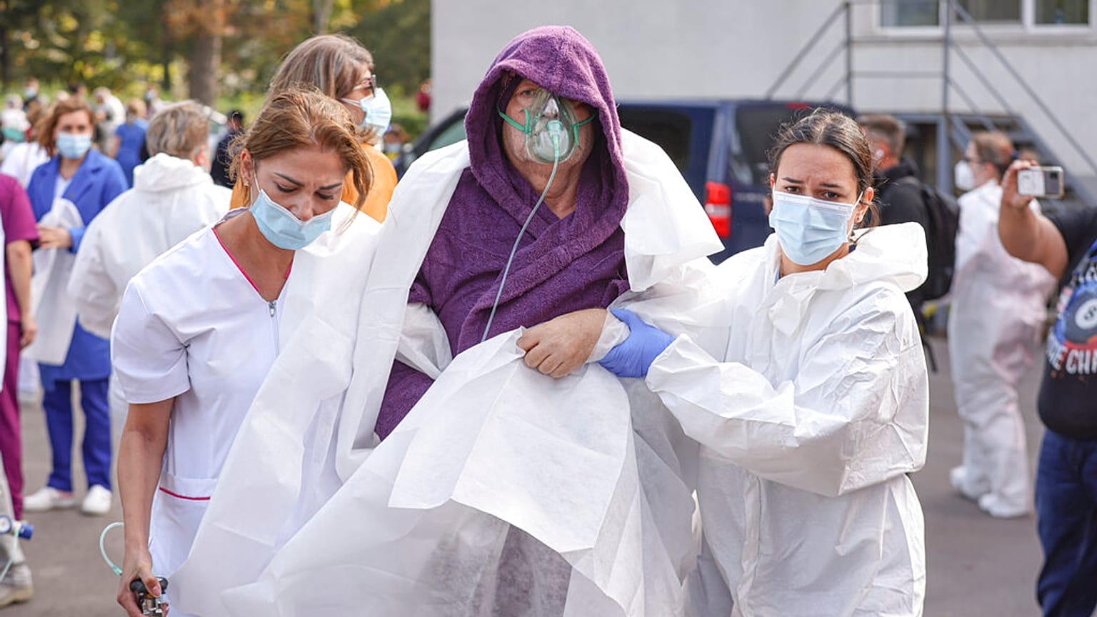 Medical staff support a patient breathing through an oxygen mask after a fire in the COVID-19 ICU section of the Hospital for Infectious Diseases in Constanta
