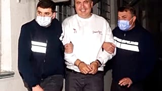 Georgian Police officers escort former President Mikheil Saakashvili after he was arrested in Rustavi, Georgia, Friday, Oct. 1, 2021. 