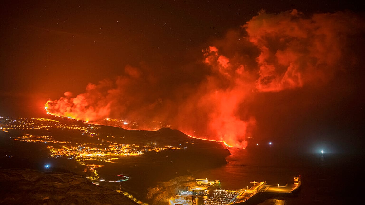 Fotografía nocturna de la lava llegando al mar en la isla de La Palma