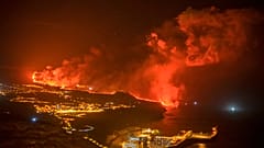 Fotografía nocturna de la lava llegando al mar en la isla de La Palma