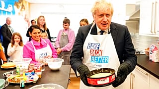 Britain's Prime Minister Boris Johnson and Home Secretary Priti Patel try baking during a visit to HideOut Youth Zone, in Manchester, England, Sunday Oct. 3, 2021.