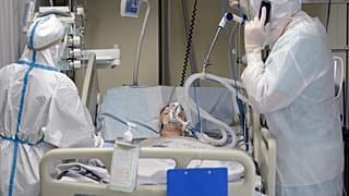 Medical workers wearing a personal protective equipment PPE tend to a patient infected with the Covid-19 at the intensive care unit of the Mariinsky Hospital.
