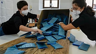Scrutineers count ballots after the closing of a polling station, in Rome, Monday, Oct. 4, 2021. 