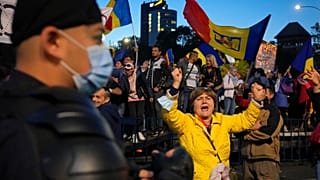 A woman shouts during an anti-government and anti-restrictions protest organized by the far-right Alliance for the Unity of Romanians or AUR, in Bucharest, Romania, Saturday,