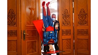 A román kormányt megbuktató parlamenti szavazás előtt Superman figuráját viszi ki valaki az ülésteremből